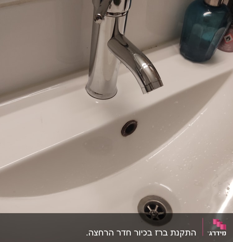 ברז כרום מעל כיור לבן עם ניקוז